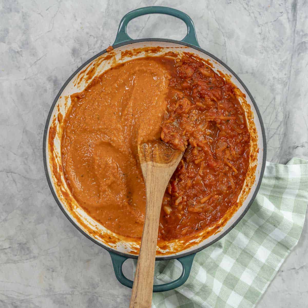 A pan of marinara sauce, half blended smooth, half chunky.