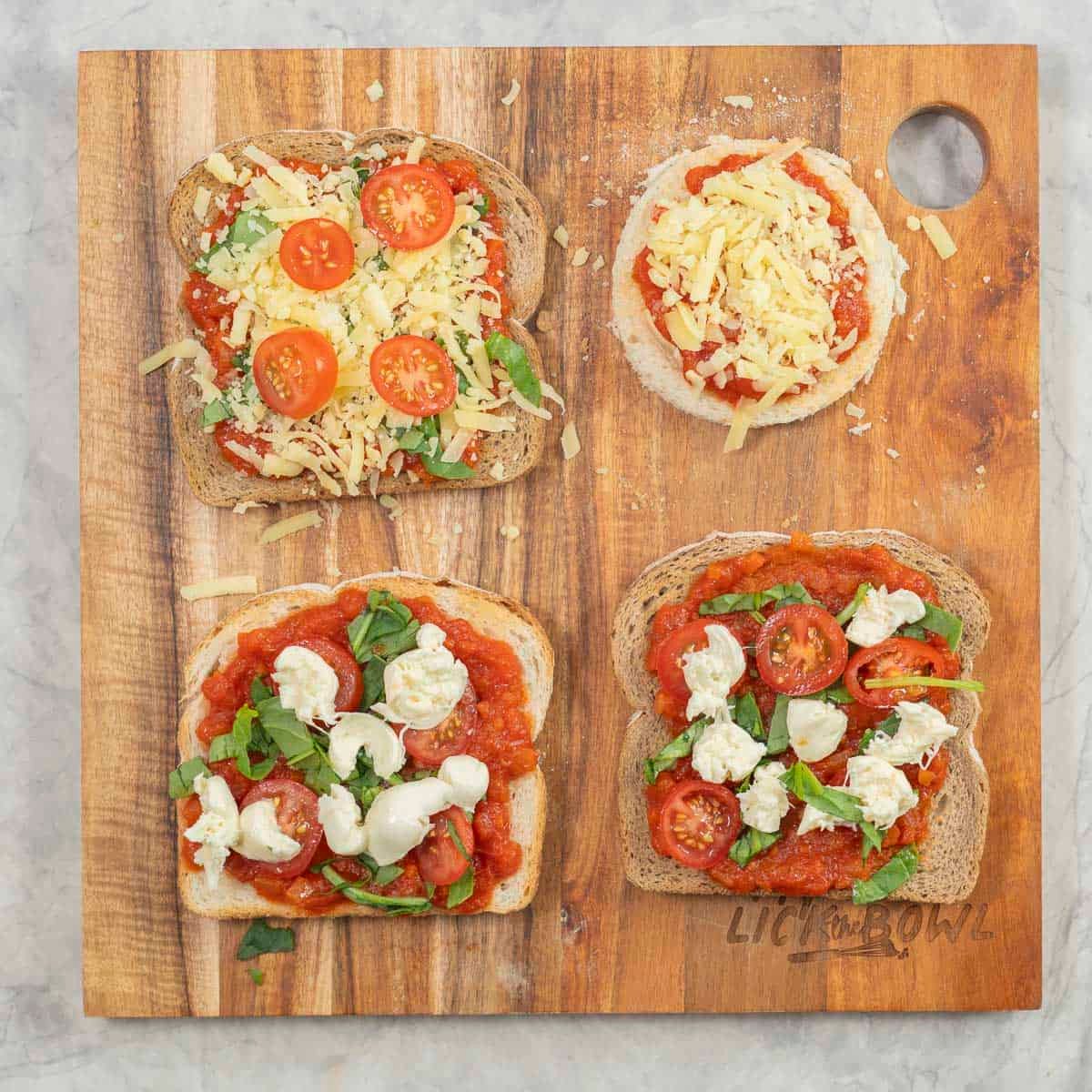 4 pieces of toast topped with pizza sauce and different toppings on a chopping board, one of the bread pizzas is round. 