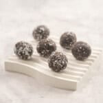 Six weetbix bliss balls on small ramekin on benchtop.