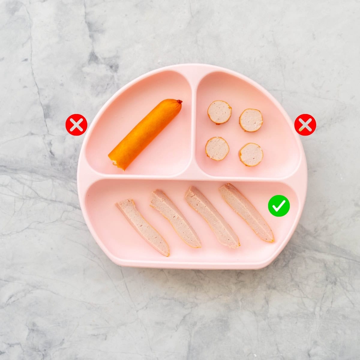 A pink baby plate with hotdogs served 3 ways, 2 with crosses one with a tick. 