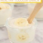 Banana yogurt with banana slices in a small glass bowl with toddler spoon, text overlay; 'Banana Yogurt, healthy toddler snack'.