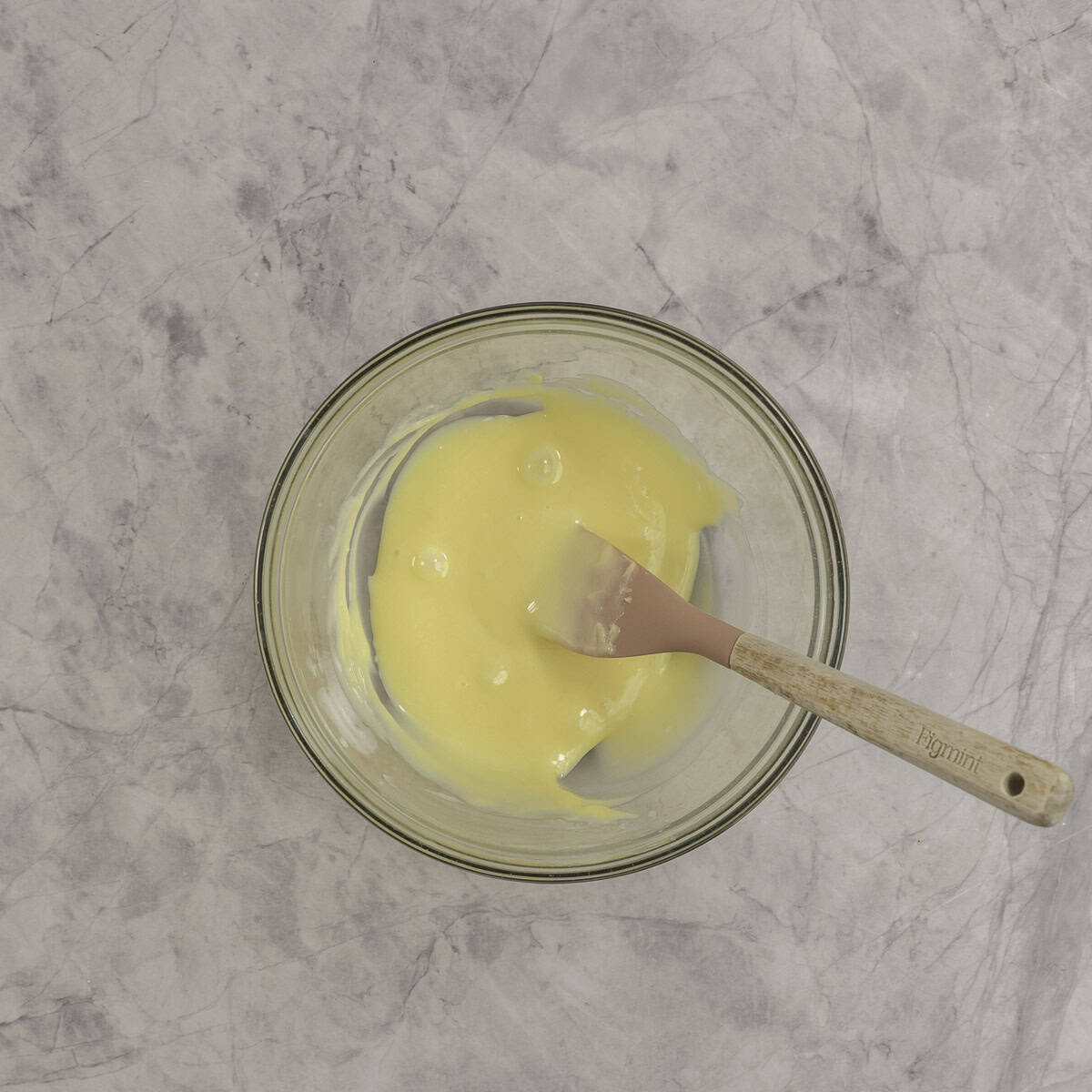 Glass bowl on bench top with wet ingredients for mint melt aways.