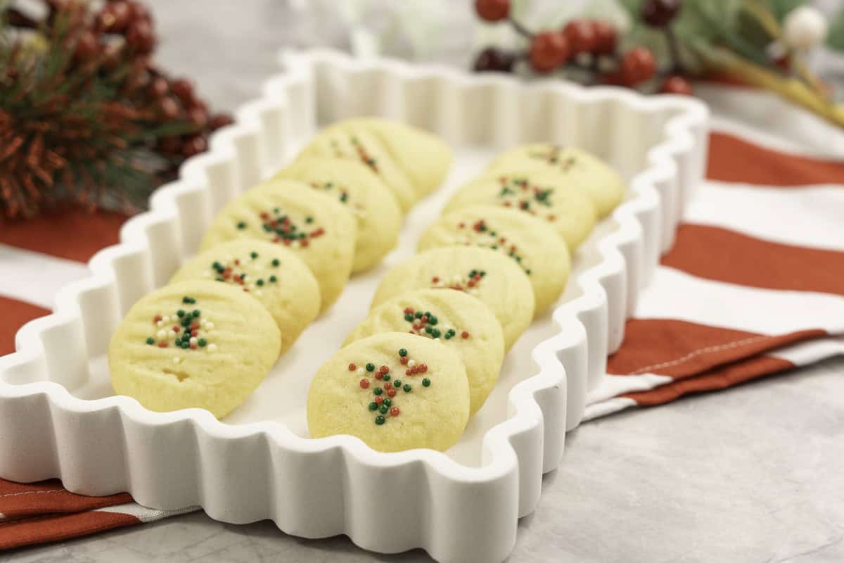 Whipped shortbread on a white tray with Christmas decorations. 